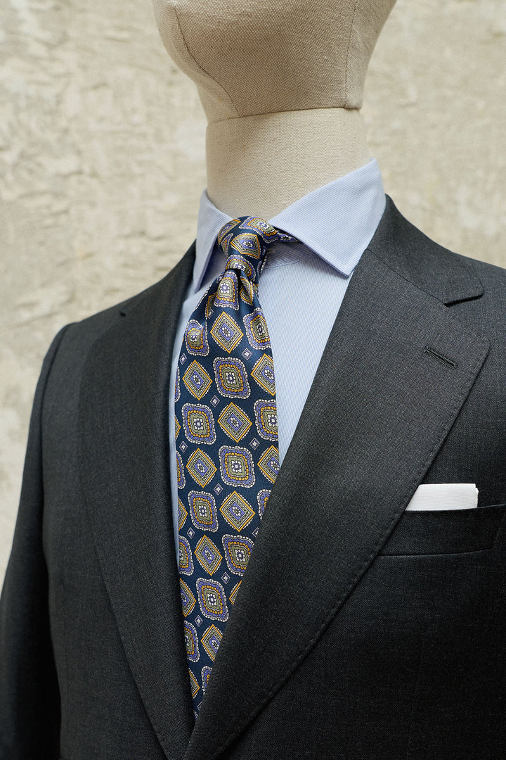 Gravata em seda Napoli, padrão geométrico azul marinho, tamanho XL, nas cores azul, amarelo e branco.