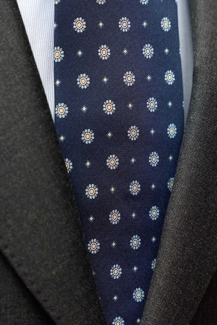 Gravata Napoli em seda azul marinho com medalhão azul e losangos cinzentos.