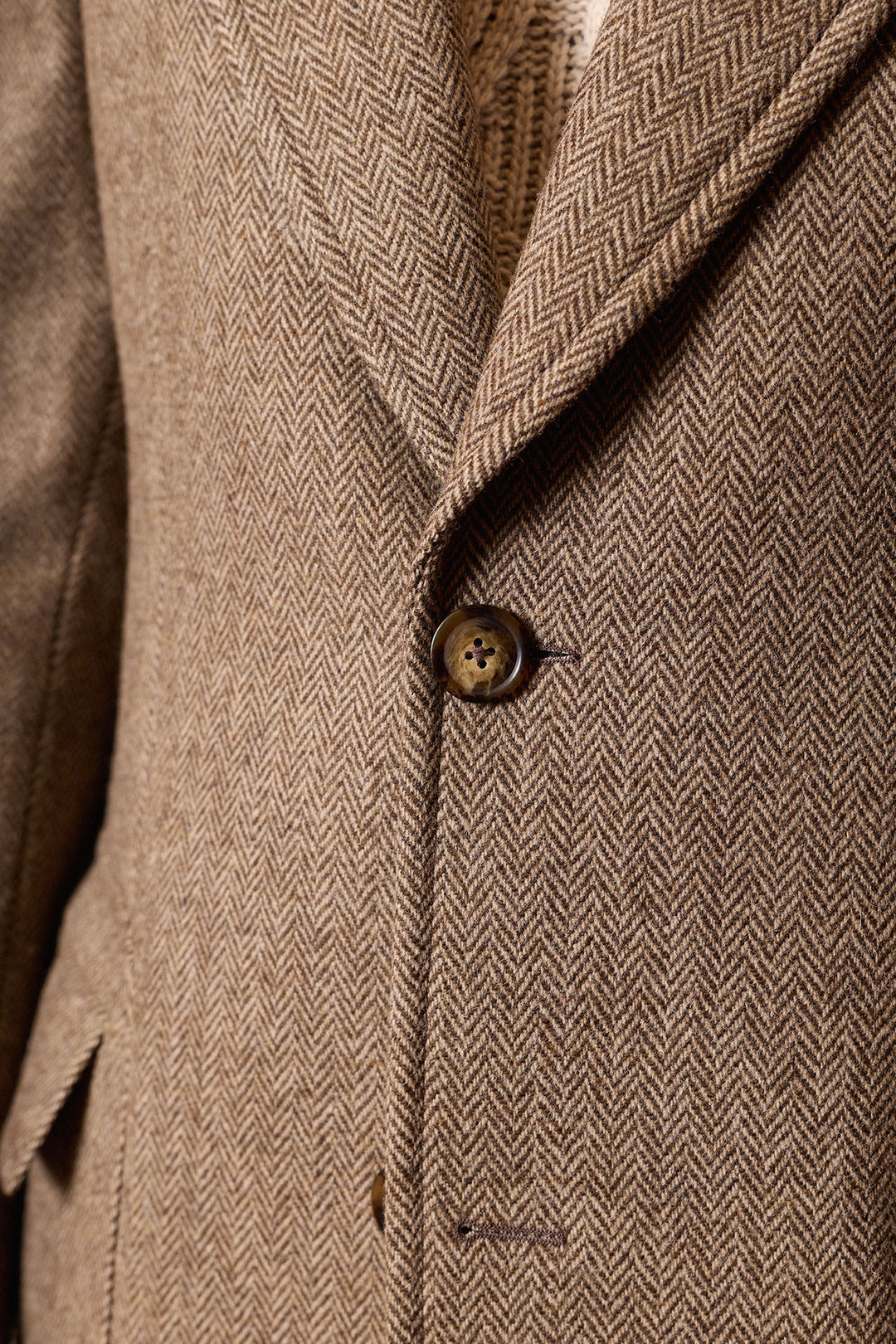 Casaco castanho com lapela em formato de ponta de lança