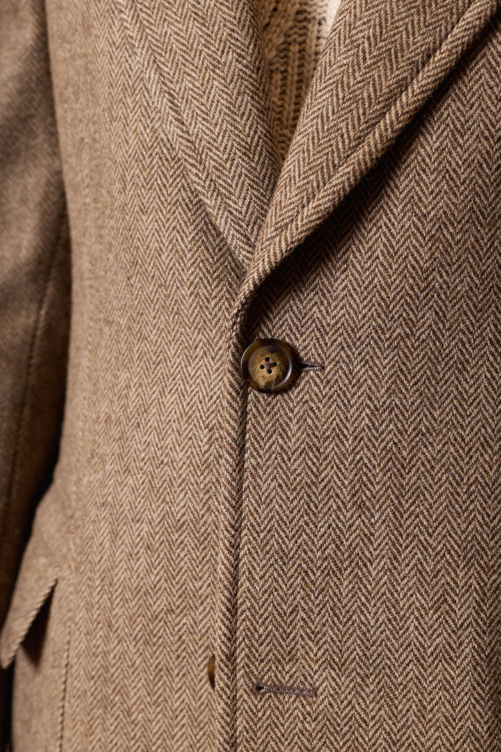Casaco castanho com lapela em formato de ponta de lança